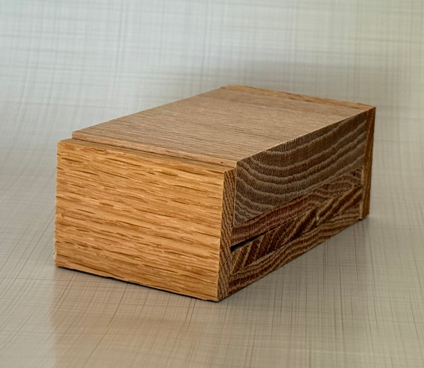Red oak cell phone stand with natural wood grain on a neutral background.