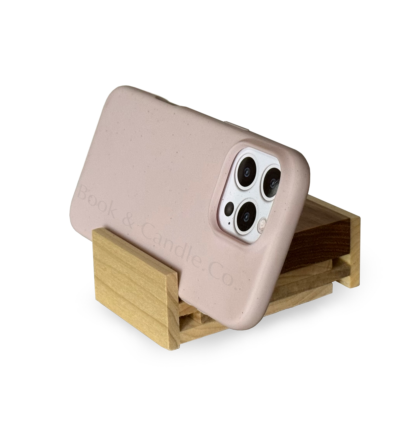 Light pink prop cell phone on an adjustable wooden stand with 'Book & Candle Co.' branding on a white background